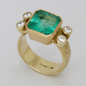 Pedestal Ring in 18K and 22ct. yellow gold with an octagon cut Emerald and four diamonds